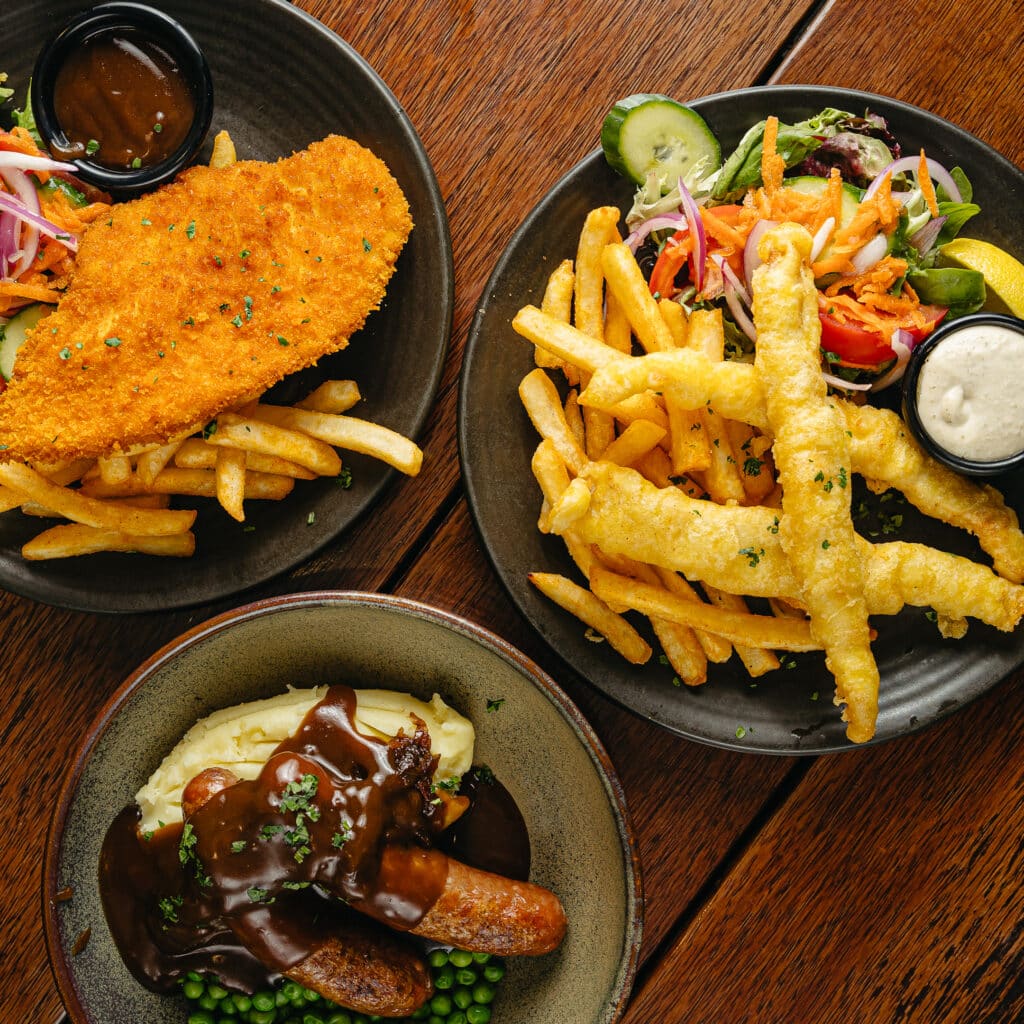 Schnitzel, Fish & chips and Bangers and Mash plated up separately