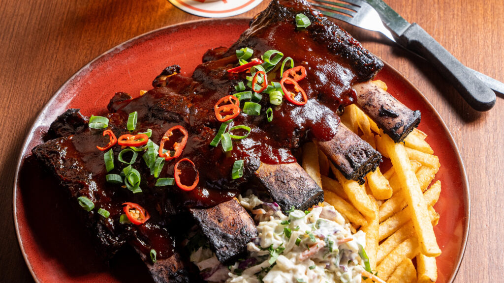 BBQ Bourbon Ribs with chips and salad on a plate