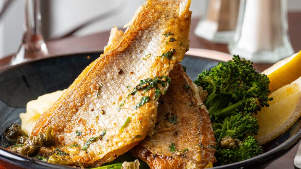 Snapper on a plate with lemon and broccolini